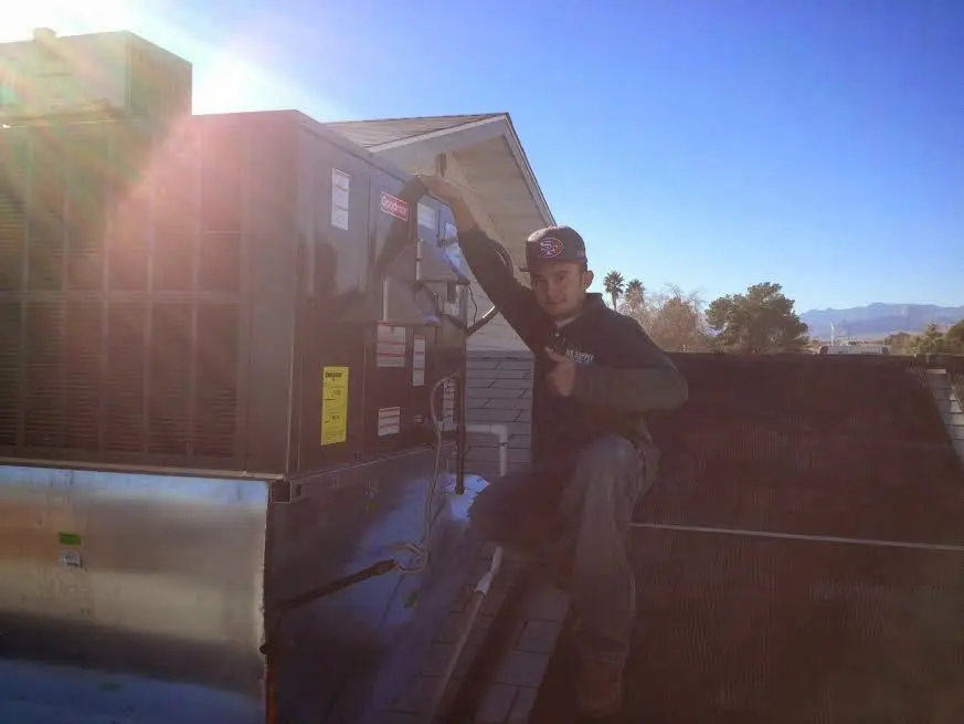 HVAC technician performing AC Tune-Up on a rooftop unit in Asbury Lake
